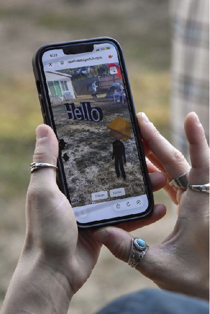 A Hello scene standing in a backyard in AR on a phone